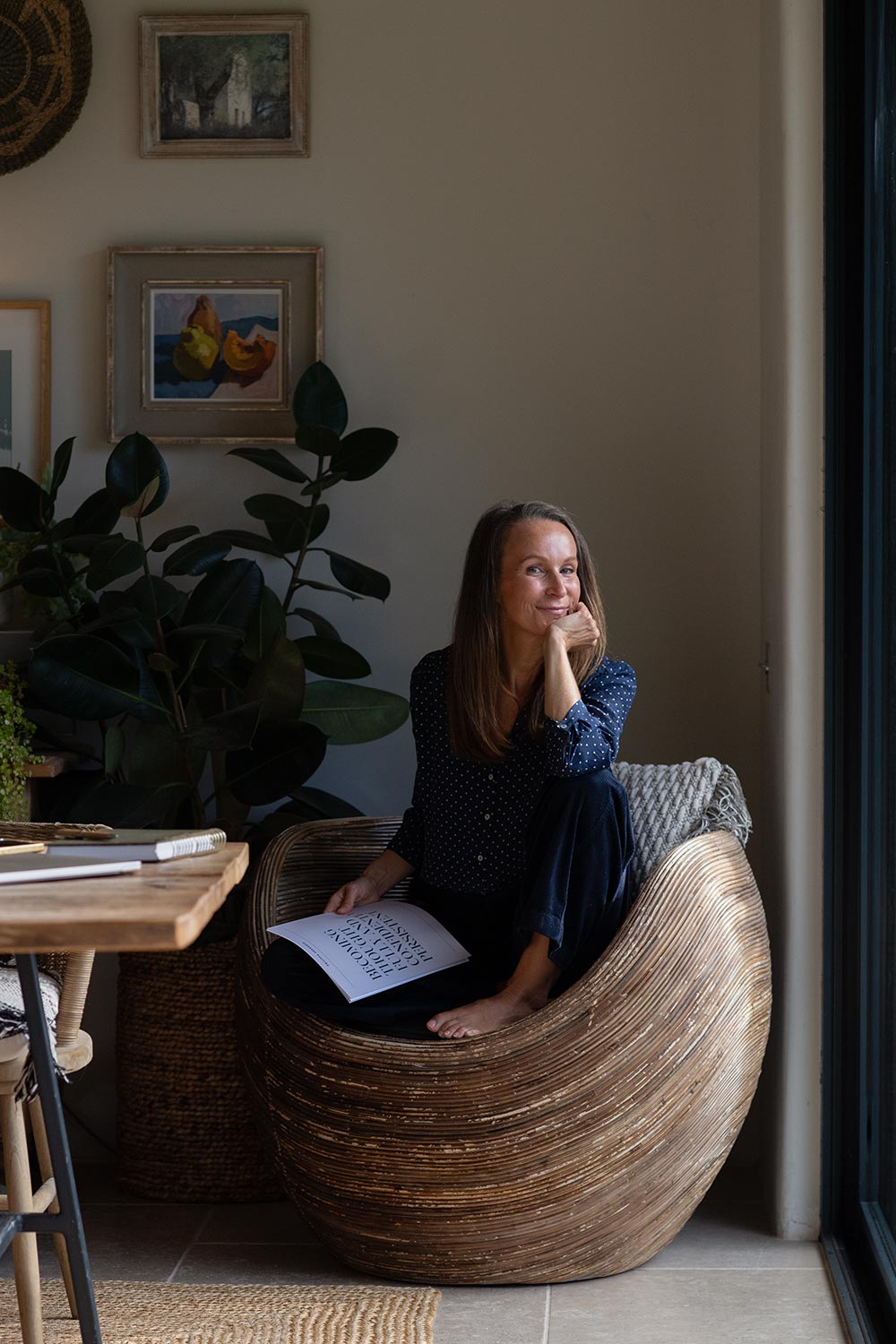 Image of a woman sitting in a chair and holding a document which contains revenue stream ideas for creative entrepreneurs